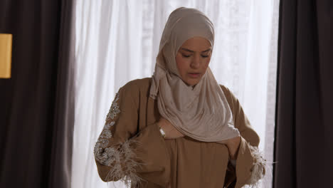 Muslim-Woman-Wearing-Hijab-At-Home-Praying-And-Bowing